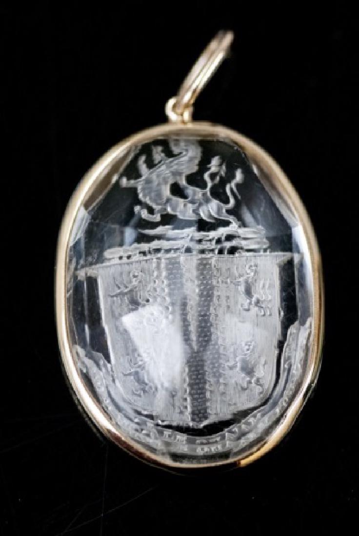 Antique 19th C Rock Crystal Armorial Pendant: Estate English Antique 19th C Carved Rock Crystal Armorial Pendant. Framed in 14kt yellow gold. Ryan Family moto "Mori Malo Quam Foedari" death rather than disgrace. Weighs approximately 8.5 grams inc