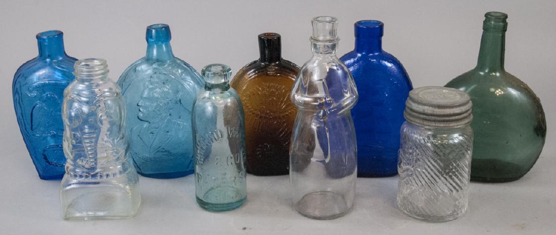 Lot of Vintage & Antique Colored Glass Bottles: Lot of Vintage and Antique Colored Glass Bottles. One Richard Warren Glass bottle. Images on bottles include eagles, Lincoln, elephants, schooners. Largest bottle is 9 inches x 4 inches.