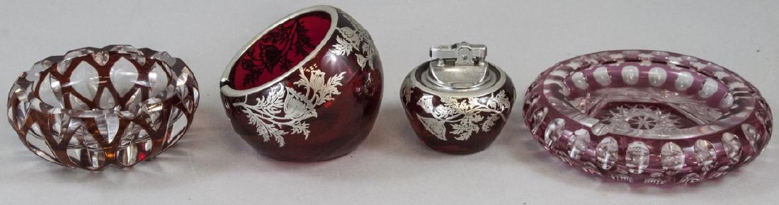 Lot of Vintage Crystal Ash Trays & Lighter: Lot of Vintage Crystal Ash Trays & Lighter. This lot includes matching red crystal ash tray and lighter with sterling overlay and two mixed maker, style, and period crystal ashtrays. Largest piece mea