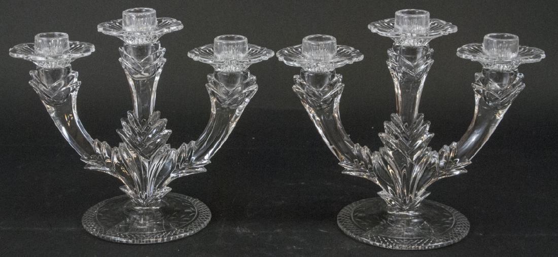 Pair of Crystal 3 Arm Candelabras: Pair of Crystal 3 Arm Candelabras. This pair of crystal three arm candelabras includes detachable bobeches and features an ornate decorative motif. Each measures 8.5 inches x 10.5 inches x 5.5 inches.