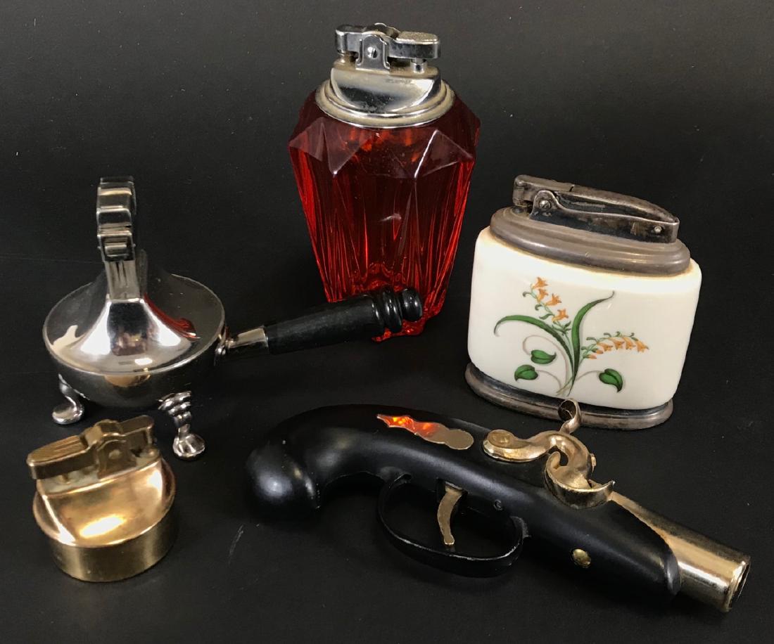 Collection of Decorative Vintage Lighters: Collection of Decorative Vintage Lighters. Assorted makers, styles and materials. Includes a pistol, hand painted porcelain, brass, bright orange glass and more. Pistol form lighter measures 6 inches.