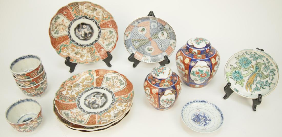 Lot of Japanese Imari Porcelain Serve Ware: Lot of Japanese Imari Porcelain Serve Ware & Decorative Objects. Includes two hand painted ginger jars, four tea cups, and seven miscellaneous plates or dishes. Largest ginger jar measures 6 inches x