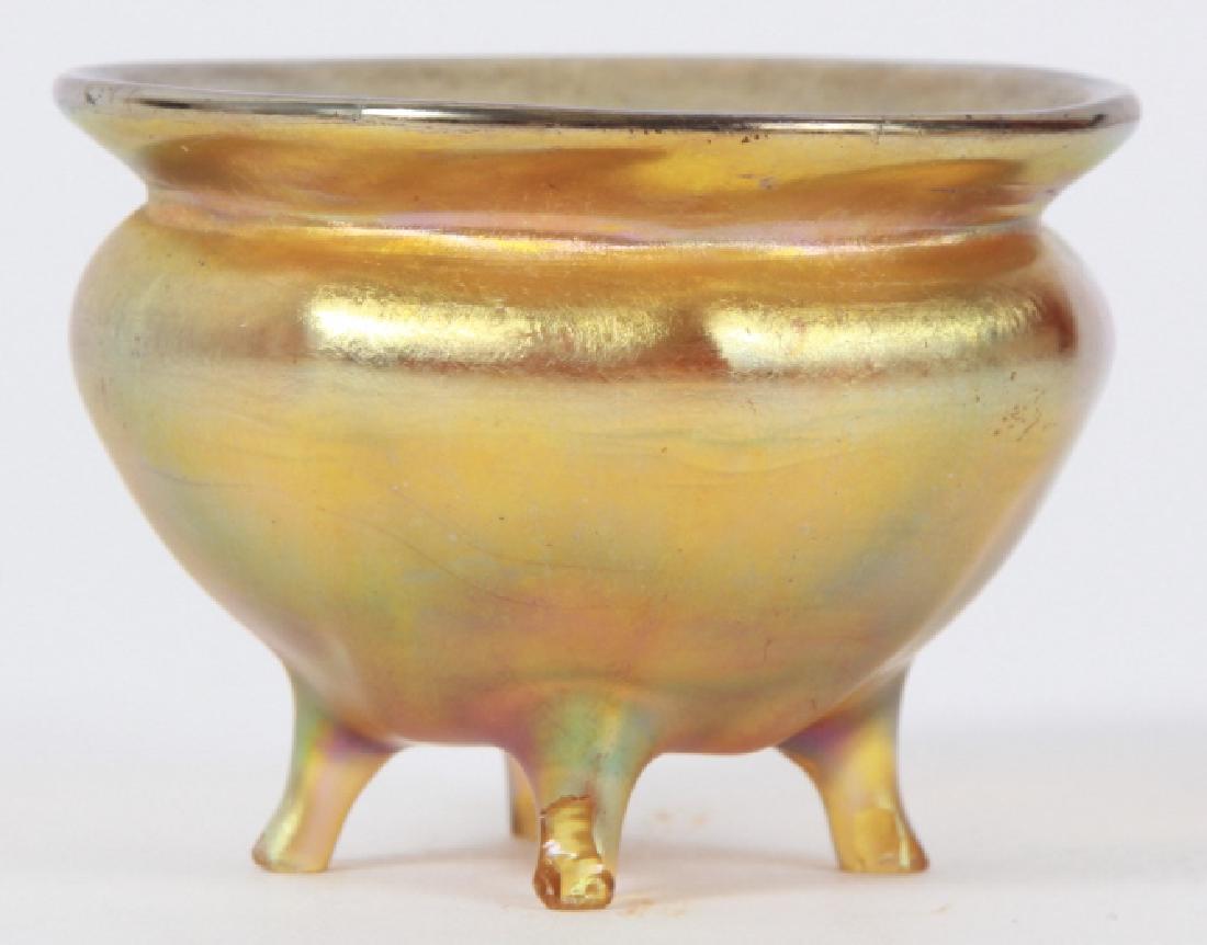Signed Louis Comfort Tiffany Favrile Glass Salt: Signed Louis Comfort Tiffany Favrile Glass Salt Cellar. Signed LCT on the bottom. Art glass favrile footed salt cellar. Measures just over 2 inches in diameter.