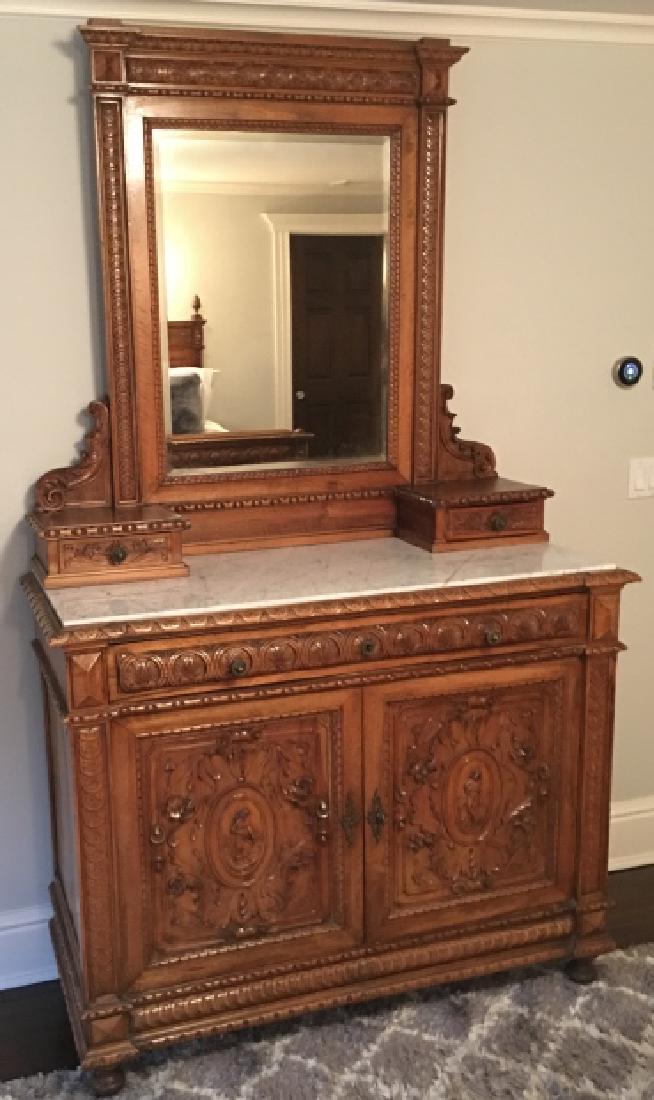 Italian Hand Carved Bureau W Marble Top & Mirror: Italian Hand Carved Bureau W Marble Top & Mirror. This lot features a heavily carved Italian dresser / bureau having neo-gothic influence. Marble top, upper mirror is beveled. 91 inches x 52 inches x 