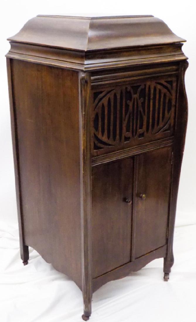 Grand Opera Phonograph and Records: Grand Opera Phonograph and Records. Phonograph in 2 door console with carved front. Turntable is operable. Comes with a selection of records. 46 inches x 19 inches x 21inches.