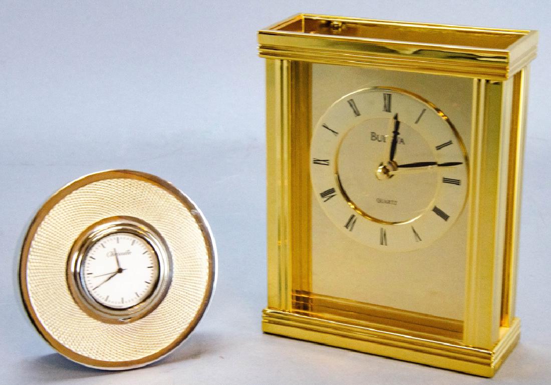 2 Vintage Bulova & Christofle Case / Desk Clocks: 2 Vintage Bulova & Christofle Case / Desk Clocks. This lot includes two vintage desk / case clocks. One gold-toned clock by Bulova and one silver-toned clock by Christofle. Largest measures 5.5 inches