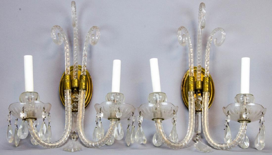 Pair Double Arm Crystal & Brass Wall Sconces: Pair Double Arm Crystal & Brass Wall Sconces. This lot features a pair of double arm wall sconces, each featuring crystal pendalogs and brass hardware. Each measures approximately 16 inches x 13 inche