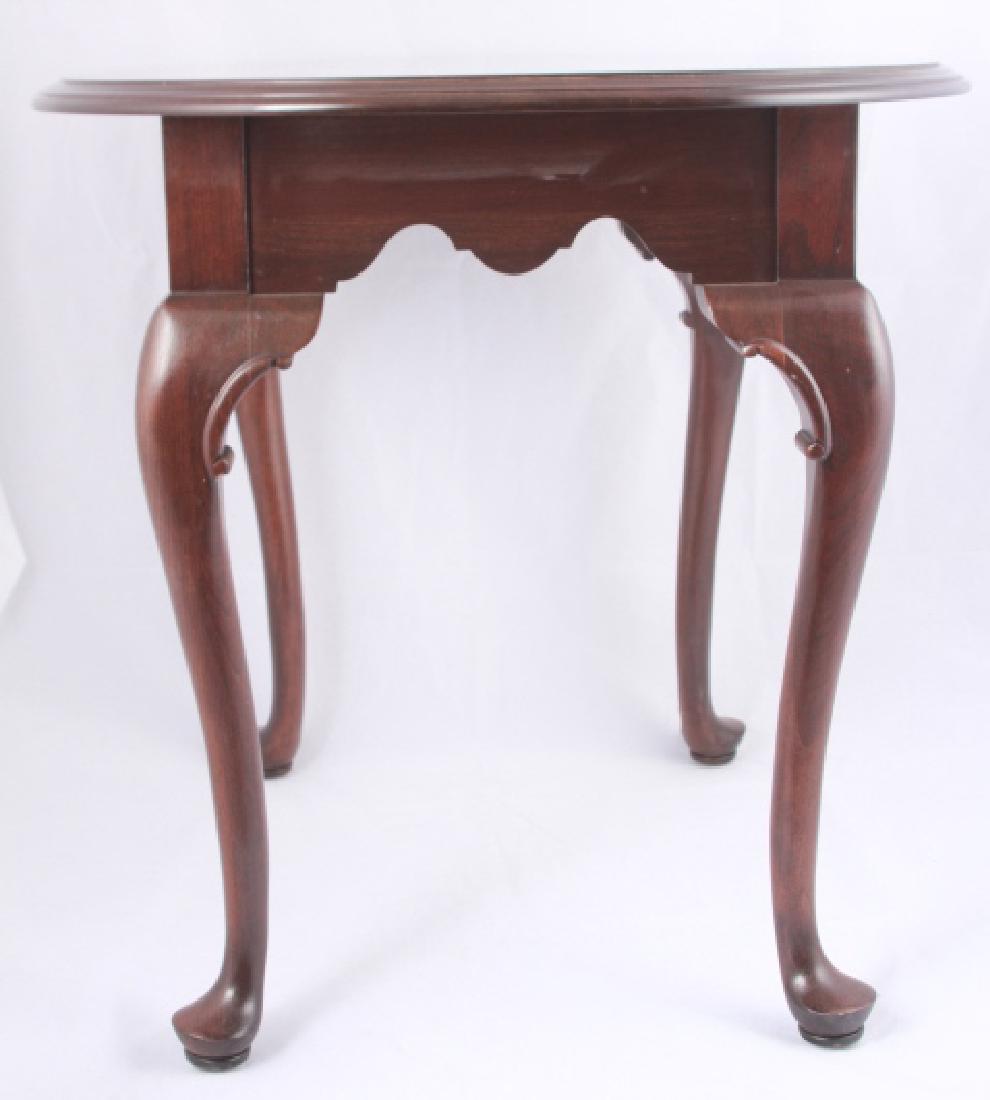 Ethan Allen Queen Anne Style Mahogany Side Table: Ethan Allen Queen Anne Style Mahogany Side / End Table. Having cabriole legs, a carved apron, and an oval table top surface. 23 inches x 28 inches x 23 inches.
