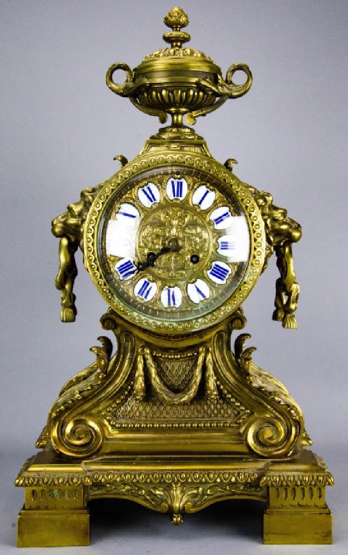 Antique French Gilt Bronze Ormolu Mantle Clock: Antique French Gilt Bronze Ormolu Mantle Clock. Having enamel roman numerals on face. Lion and Neo Classical cast details. Measures 22.5 x 13 x 8 inches.