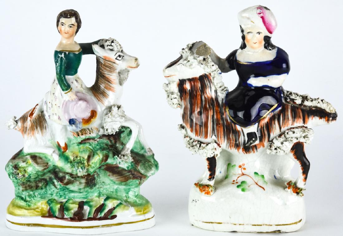 2 English Staffordshire Porcelain Figural Statues: 2 English Staffordshire Porcelain Figural Statues. Both feature women riding goats and have hand painted details. Larger measures 6 inches x 5 inches x 2 inches.