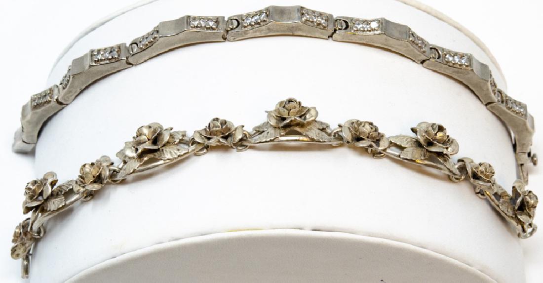 Pair Sterling and 800 Silver Link Bracelets: Pair Sterling Silver Link Bracelets. 800 silver bracelet features roses in relief (7 inches long). Other is a contemporary style link with treated clear stones (8 inches long).