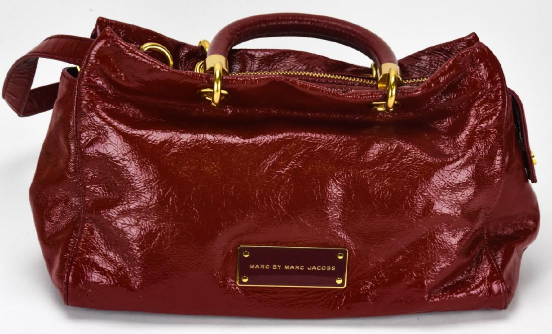Marc by Marc Jacobs Leather Handbag / Purse: Marc by Marc Jacobs Leather Handbag / Purse. Red cow leather handbag with gold toned hardware by Marc Jacobs. Measures approximately 8 inches x 11 inches x 4 inches without straps. Property of an Irvi