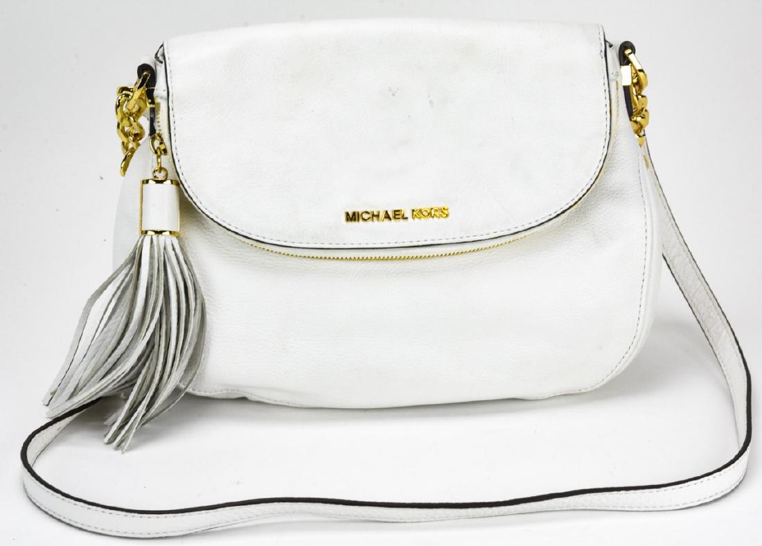 Michael Kors Leather Handbag / Purse: Michael Kors Leather Handbag / Purse. White leather handbag with gold toned hardware by Michael Kors. Measures approximately 8 inches x 11 inches x 3 inches without strap. Property of an Irvington, Ne