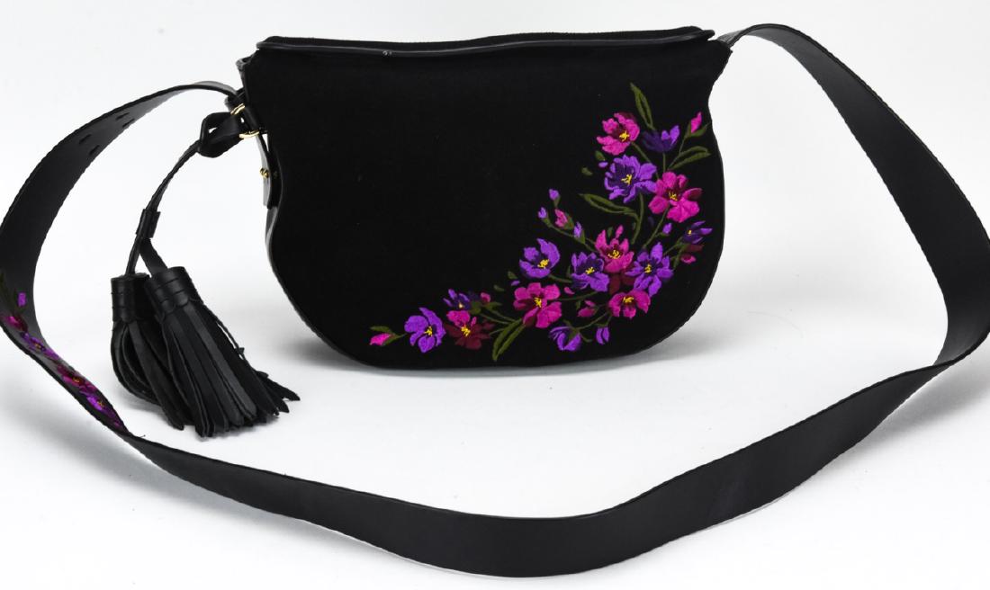 Isaac Mizrahi Floral Suede & Leather Saddle Bag: Isaac Mizrahi Floral Suede & Leather Saddle Bag / Purse. Embroidered with a floral motif. Measures approximately 7 inches x 10 inches x 2.5 inches without strap. Property of an Irvington, New York est