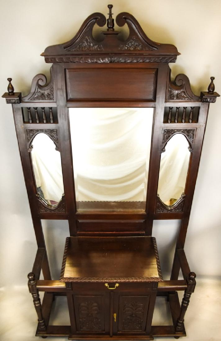 Victorian Style Carved Mahogany Hall Tree: Victorian Style Carved Mahogany Hall Tree. Features three mirrored panels, one pull out drawer, one cabinet and umbrella / cane holders. Heavily carved with pediment. 94 inches x 48 inches x 18 inches