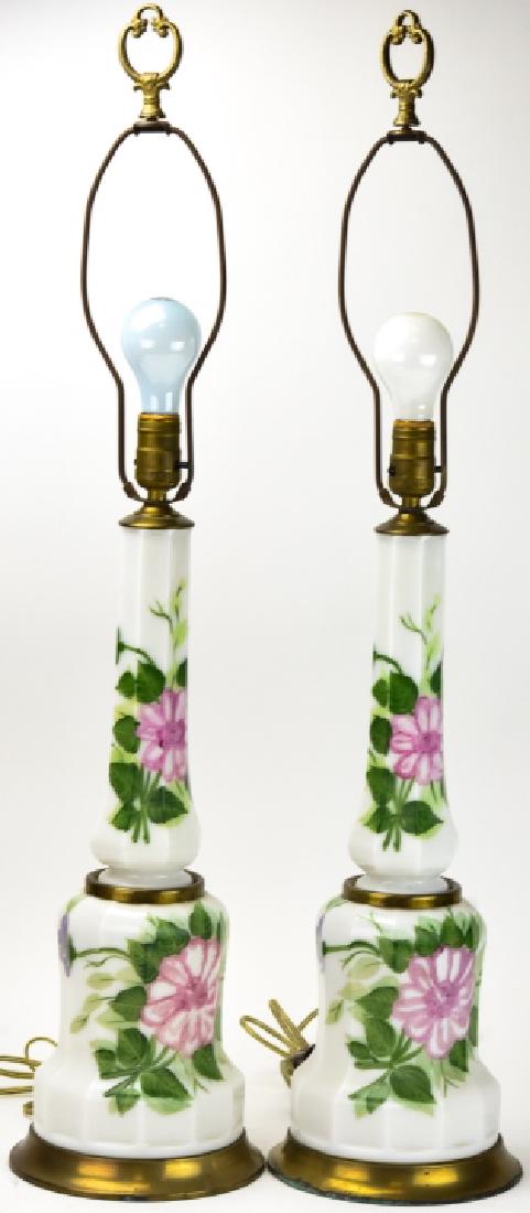 Pair Hand Painted Milk Glass Table Lamps: Pair Hand Painted Milk Glass Table Lamps. Milk glass base with hand painted floral motif. 34 inches x 7.5 inches in diameter with harp.