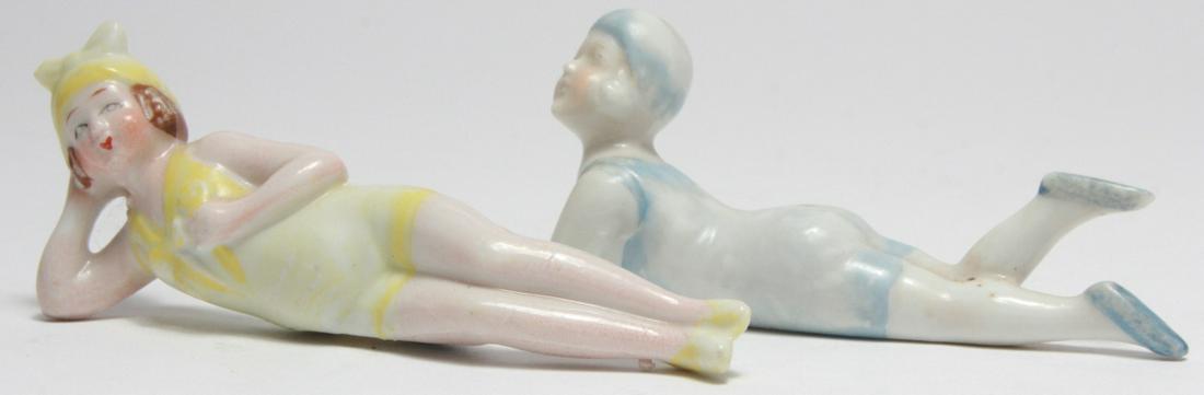 Pair Vintage Bathing Beauty Porcelain Figures: Pair Vintage Bathing Beauty Porcelain Figures. One figure is in pink reclining on her elbow, the other is in blue reclining with elbows crossed. Both are made in Japan. 4 inches x 2 inches.