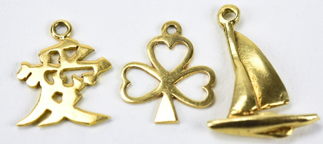 Three Vintage 14kt Yellow Gold Charms: Three Vintage 14kt Yellow Gold Charms. Four leaf clover, sailboat, Chinese character. Each under 1 inch in length.