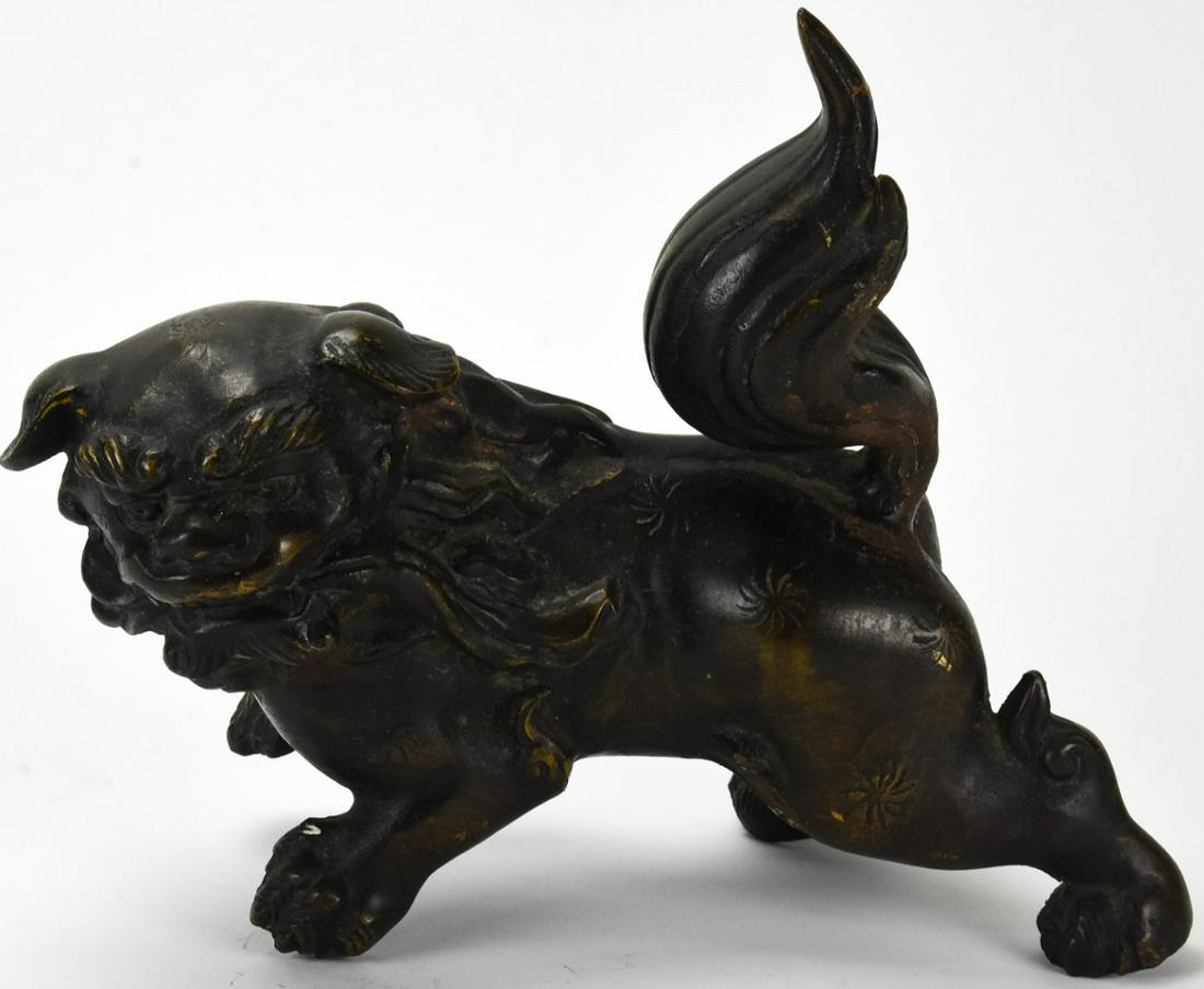 Large Bronze Standing Foo / Palace Dog: Large Bronze Standing Foo / Palace Dog. Dog stands on all fours. Carries sash in mouth. Detailed face and body. 12 inches x 12 inches x 8 inches