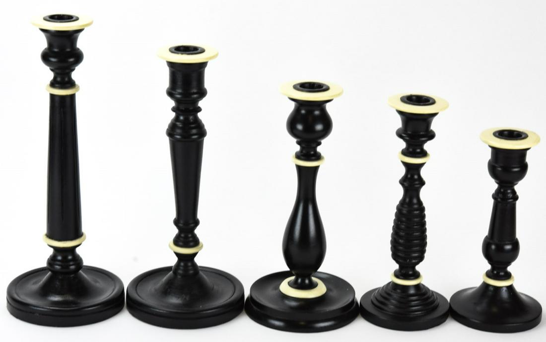 5 Carved Baluster Form Black / Ivory Candlesticks: 5 Carved Baluster Form Black / Ivory Candlesticks. Baluster form candlesticks, turned wood, painted black with ivory Bakelite like material accents. Tallest is 12 inches and shortest is 8 inches.
