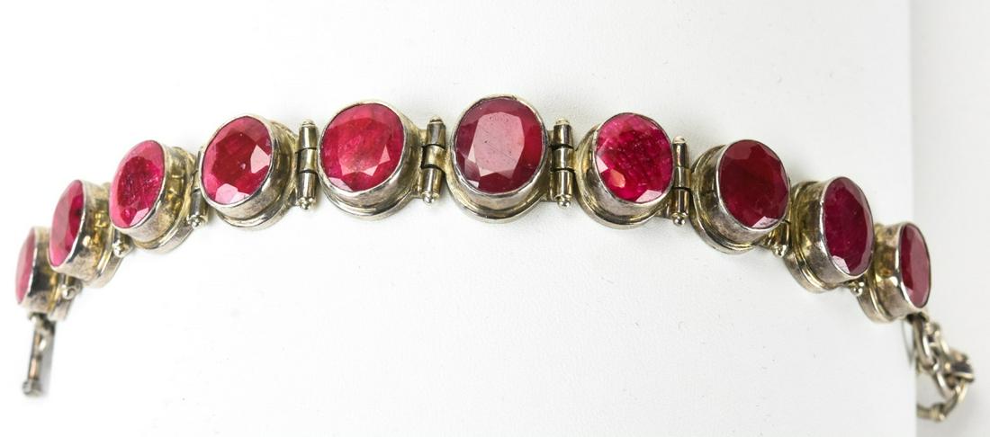 Sterling Silver & Red Stone Bracelet: Sterling Silver & Red Stone Bracelet. Sterling silver bracelet with ten faceted red stones in handmade bezel settings. Measures 8.5 inches in total length, adjustable toggle clasp. Hallmarked.