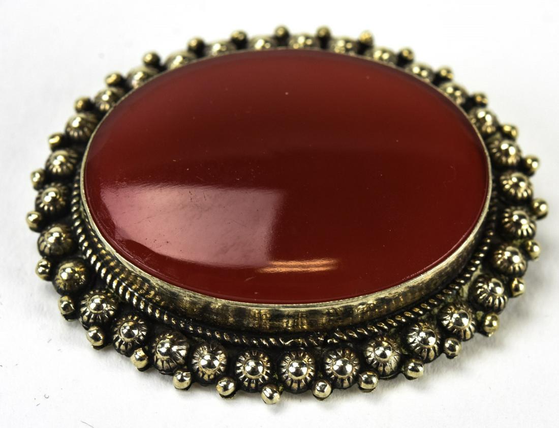 Italian Sterling & Carnelian Cabochon Brooch: Italian Sterling & Carnelian Cabochon Brooch. Oval form brooch with large carnelian cabochon at center. Hallmarked on back. Measures 1.5 inches x 1.75 inches.