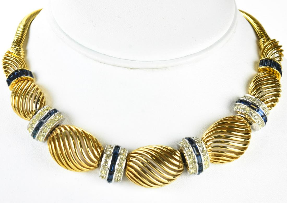 Boucher C 1950 Gilt Retro Swirl Link Necklace: Boucher C 1950 Gilt Retro Swirl Link Necklace. With blue and clear paste set links. Signed on panel. Measures approximately 14 inches.