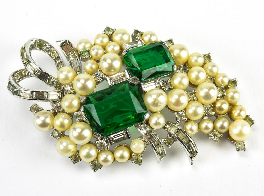 Jomaz C 1980 Rhodium & Pearl Cluster Brooch: Jomaz C 1980 Rhodium & Pearl Cluster Brooch. Faux pearl and faux emerald cluster brooch set in rhodium. Marked Jomaz. Measures 2 5/8 inches x 1.5 inches.