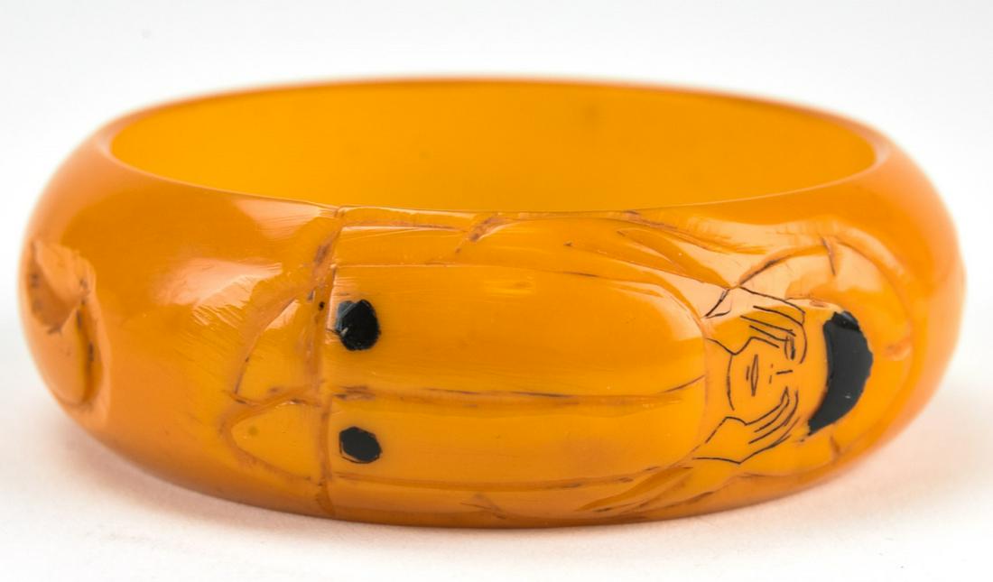Rare Wide Carved Bakelite Bangle Bracelet: Rare Wide Carved Bakelite Bangle Bracelet. With pierrot and crescent moon design carved butterscotch bakelite. Circa 1945. Measures 1 inch wide, 2.5 inches across interior opening.