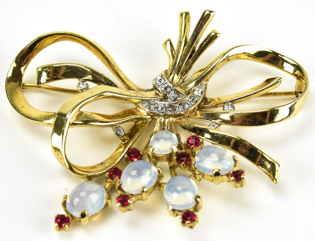 Vintage 1940s Trifari Floral & Bow Motif Brooch: Vintage 1940s Trifari Floral & Bow Motif Brooch. Sterling silver with gilt wash, rhinestones and faux moonstone cabochons. Signed. Measures 2.5 inches in width.