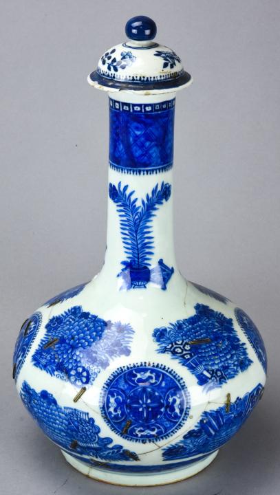Antique Chinese Blue & White Fitzhugh Bottle: Antique Chinese Blue & White Fitzhugh Bottle. Antique Chinese Fitzhugh blue and white porcelain bottle with cover. With staple repairs. Measures approximately 15.5 inches x 8 inches in diameter.