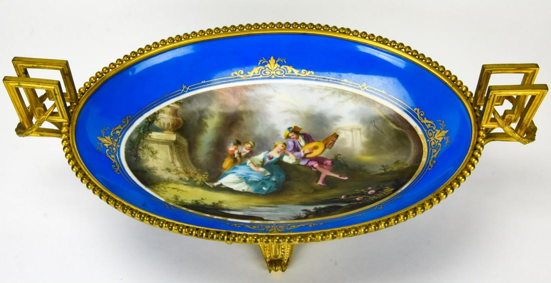 Sevres Painted Porcelain & Ormolu Fruit Platter: Sevres Painted Porcelain & Ormolu Fruit Platter. Porcelain fruit platter with hand painted courtship scene with ormolu handles and base. Measures 6.5 inches x 19 inches x 10.5 inches. Unsigned, attrib