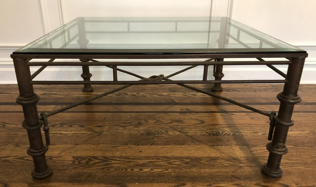 Wrought Iron & Glass Southwestern Coffee Table: Wrought Iron & Glass Southwestern Coffee Table. Southwestern style with a wrought iron base featuring knot and tassel motif on wrapped legs and stretchers. Glass top. 19 inches x 35 inches x 36 inches
