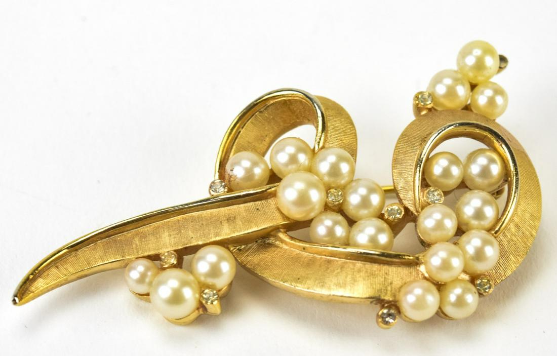 Trifari C 1975 Retro Pearl Cluster Brooch: Trifari C 1975 Retro Pearl Cluster Brooch. Textured gilt metal swirl design with faux pearl clusters. Signed on back. Measures 2.25 inches in width.