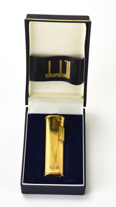 Vintage Mid Century Dunhill Lighter W Original Box: Vintage Mid Century Dunhill Lighter W Original Box. Gold toned lighter with original fitted box. Measures 2.75 inches in length, box measures 4 inches x 2.25 inches.