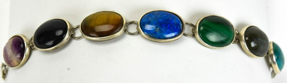 Vintage Sterling Silver Cabochon Gemstone Bracelet: Vintage Sterling Silver Cabochon Gemstone Bracelet. Set with amethyst, tiger's eye, lapis lazuli, turquoise, onyx, malachite. Measures 7.5 inches in length.
