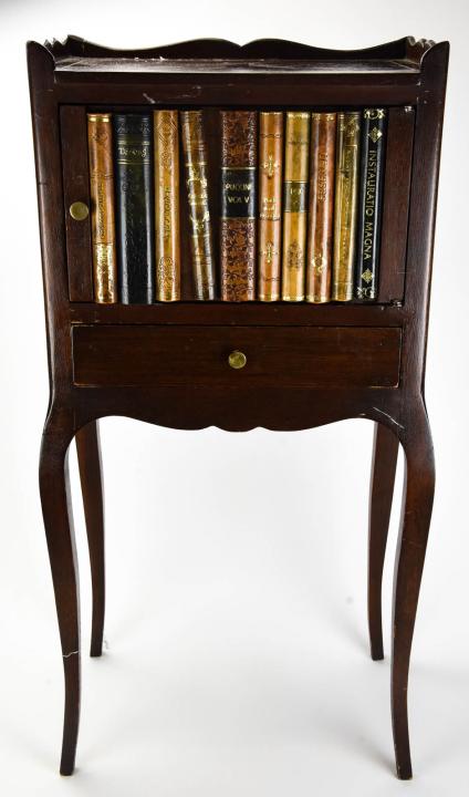 Maitland-Smith Book Form Side / End Table: Maitland-Smith Book Form Side / End Table. Side table with lower drawer and upper cabinet with hard back book motif with Maitland-Smith plaque. Measures 28 inches x 13.5 inches x 9 inches.