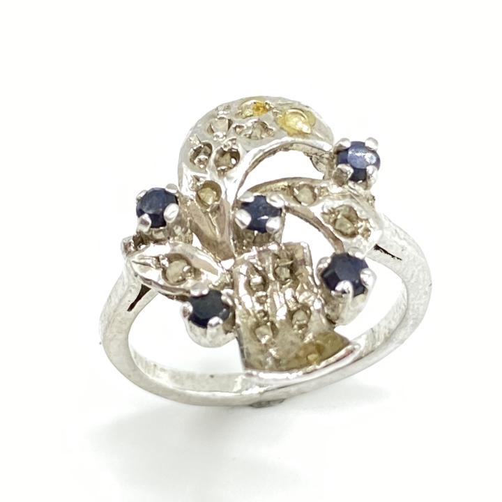 Vintage Diamond & Natural Sapphire Ring: Vintage Diamond & Natural Sapphire Ring. Diamonds and Sapphire are set in rhodium plated sterling silver. About a Size 6. Approx .75” tall at tallest point.
