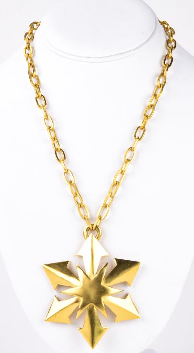 1975 Trifari Gilt Metal Snowflake Pendant W Chain: 1975 Trifari Gilt Metal Snowflake Pendant W Chain. Pendant is signed. Chain measures 19 inches. Pendant measures 3 inches.