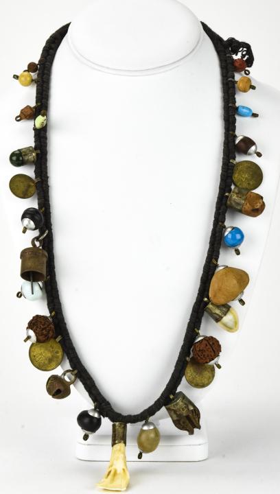 Vintage Unique African Talisman Charm Necklace: Vintage Unique African Talisman Charm Necklace. Featuring various charms such as teeth, claws, shells, trade beads, coins / medals, etc. Measures 27 inches in length.