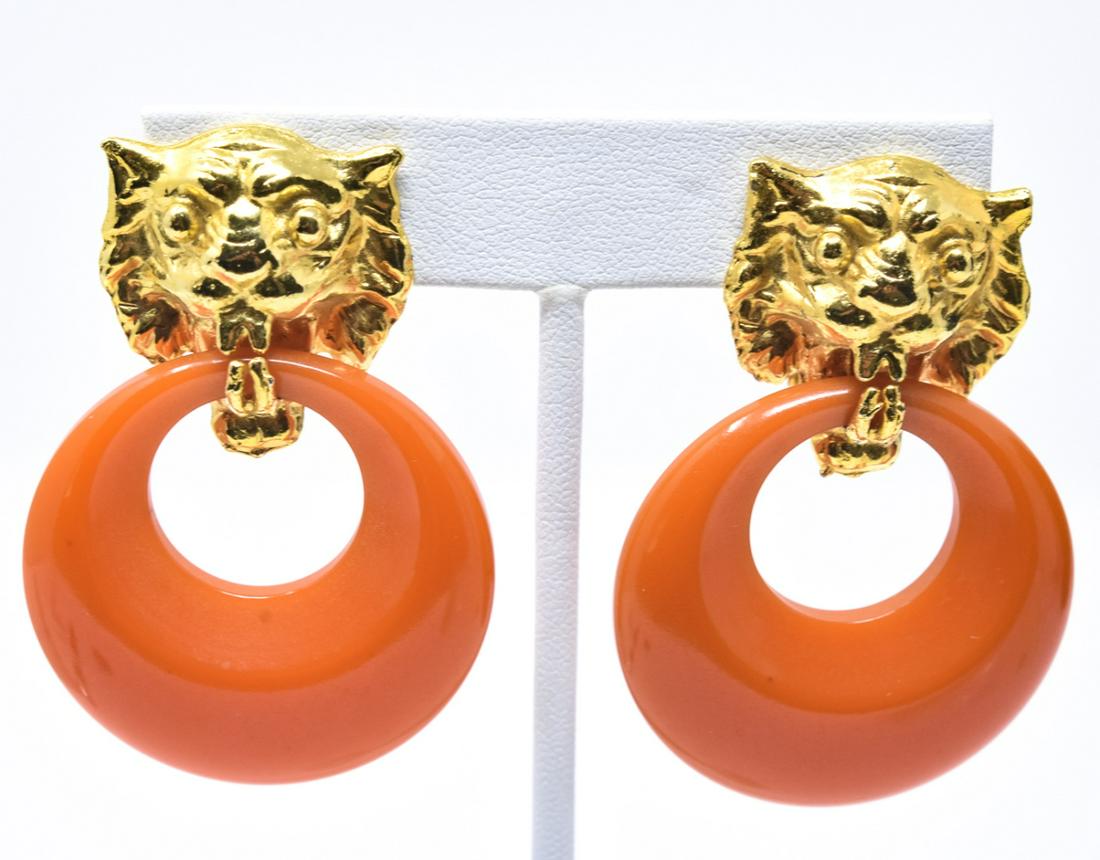 Vintage C 1970 Bakelite Door Knocker Earrings: Vintage C 1970 Bakelite Door Knocker Earrings. Clip earrings with gilt metal lion heads holding orange bakelite rings. Retro design. 2 inches in length.