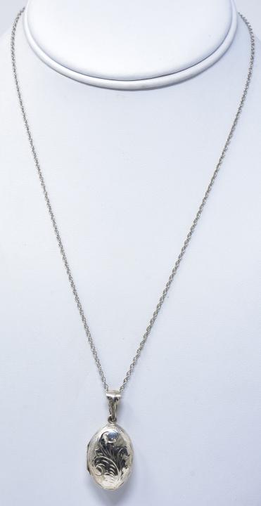 Vintage Sterling Silver Chased Locket Necklace: Vintage Sterling Silver Chased Locket Necklace. Puffy oval locket necklace pendant on rope chain. Chain measures 18 inches in length.