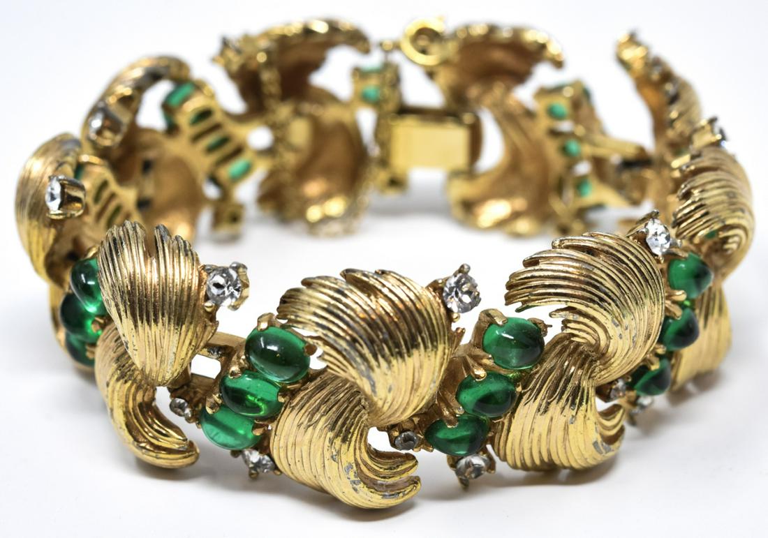 Vintage Boucher Emerald Paste Cabochon Bracelet: Vintage Boucher Emerald Paste Cabochon Bracelet. Signed. Measures 7 inches in length. Has safety chain. Gilt metal swirls with emerald paste cabochons and clear rhinestones.