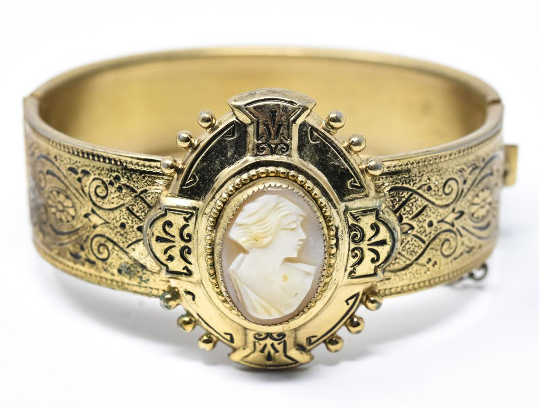 Victorian Style Bracelet w Carved Shell Cameo: Victorian Style Bracelet w Carved Shell Cameo. Gilt metal with black aesthetic movement design and safety chain. Hand carved natural shell cameo. Measures just over 2.25 inches across interior opening