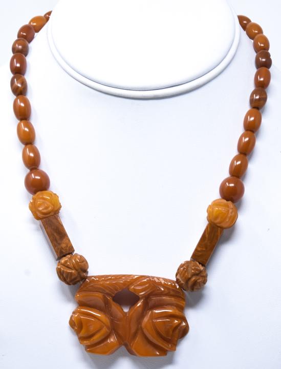 Vintage Carved Bakelite Necklace in Amber Tones: Vintage Carved Bakelite Necklace in Amber Tones. Chinese design motif. Measures 17.25 inches in length.