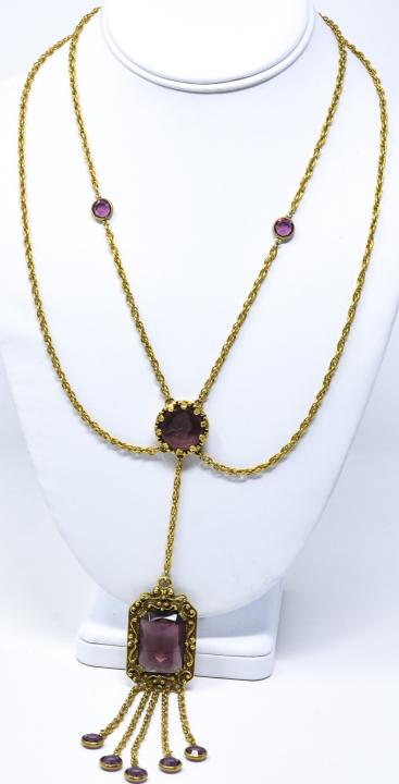 Vintage C 1970s Gilt & Amethyst Glass Necklace: Vintage C 1970s Gilt & Amethyst Glass Necklace. Unsigned, possibly by Goldette. Featuring a portrait intaglio, two strands of swagged chaining, pendant and tassels. Measures 19 inches plus 8 inch pend