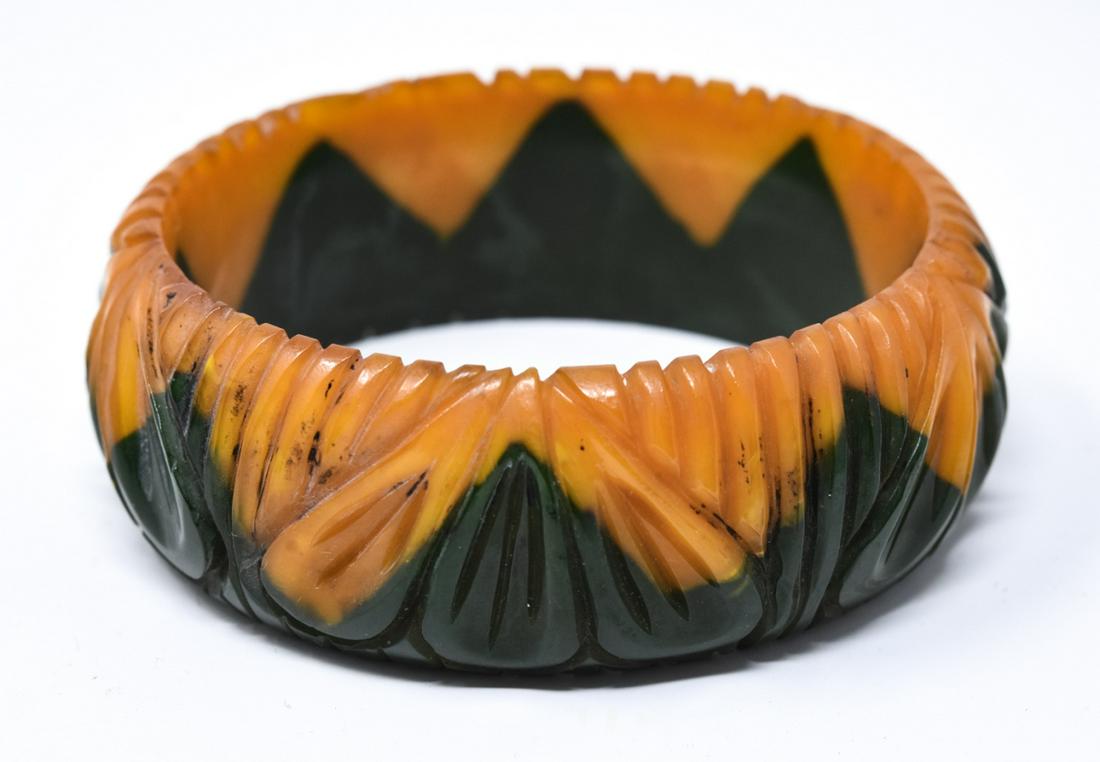 Vintage C 1940s Carved Two Tone Bakelite Bracelet: Vintage C 1940s Carved Two Tone Bakelite Bracelet in Yellow & Green. Carved and laminated, with ribbing and trefoil design. Measures 2.5 inches across interior opening. Measures just over 1 inch in wi