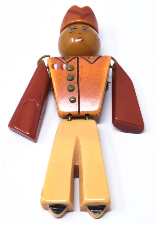 Vintage Carved & Painted Bakelite Solider Brooch: Vintage Carved & Painted Bakelite Articulated Solider Brooch. Measures 3.5 inches in length.