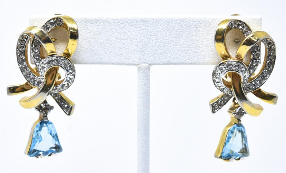 Vintage Kramer of NY Clip on Rhinestone Earrings: Vintage Kramer of NY Clip on Rhinestone & Gilt Metal Earrings. Clear and aqua tone rhinestones, bow with bell pendant motif. Each measures just over 1.5 inches in length.