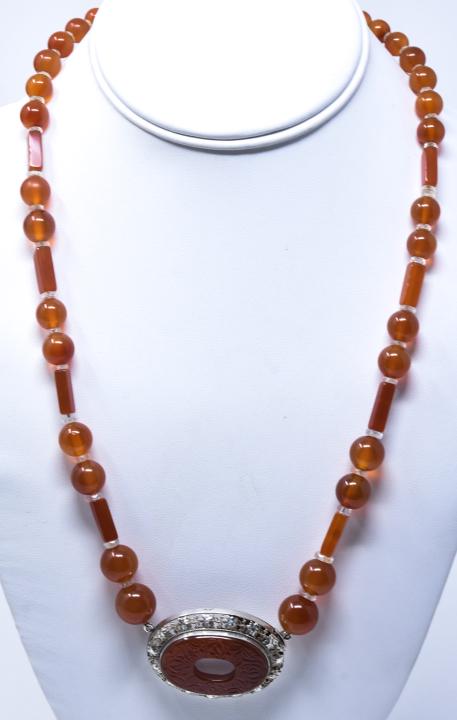 C 1920 Art Deco German Sterling Carnelian Necklace: C 1920 Art Deco German Sterling Carnelian Necklace. Art deco necklace with round and tubular carnelian beads and carved front panel. 20 inches. Hallmarked Sterling & Germany.
